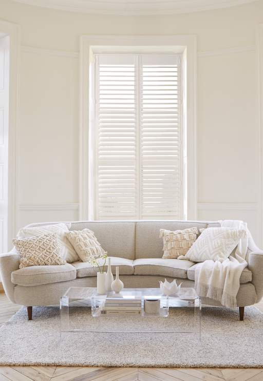 Full height shutters in Suffolk installed in a living room decorated in neutral colours