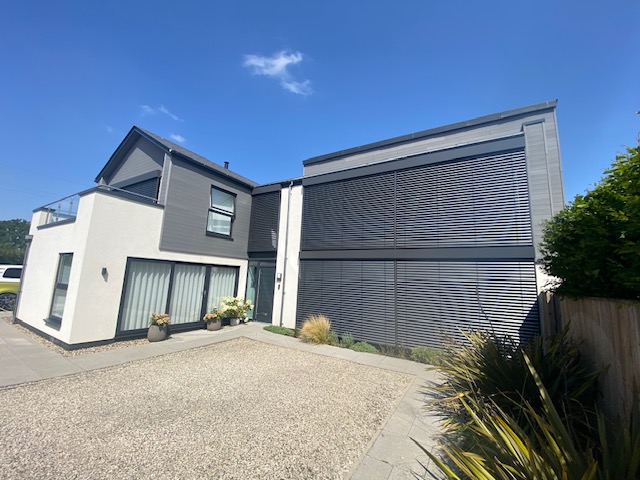Contemporary house exterior featuring external venetian blinds on upper and ground-floor windows